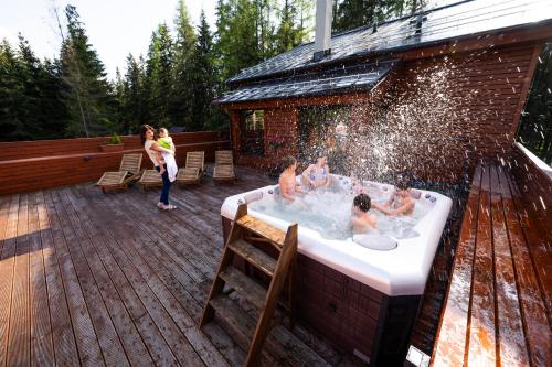 un grupo de personas en una bañera de hidromasaje en una terraza en Villa Drosera s wellnessom, Račkova dolina v Západných Tatrách en Pribylina