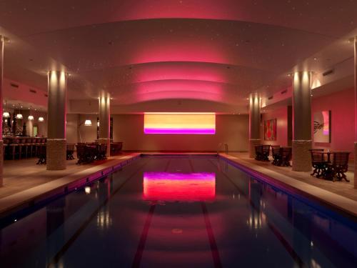 a swimming pool in a hotel with a purple lighting at Haymarket Hotel, Firmdale Hotels in London