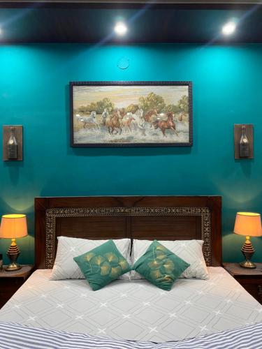 1 dormitorio con 1 cama con pared azul en The Comfort Lodge, en Islamabad