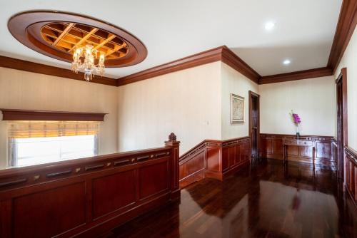 a large room with wood paneling and a chandelier at Orchid Pool Villa Phuket - SHA Extra Plus in Phuket Town