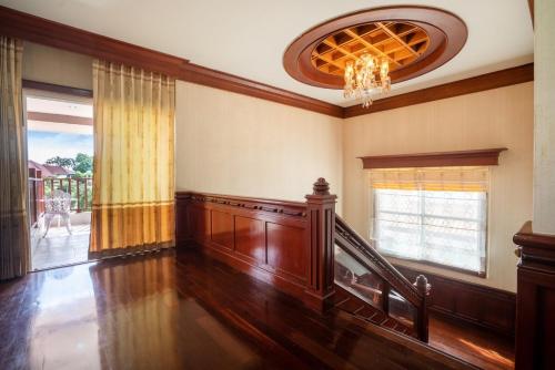a living room with a staircase and a chandelier at Orchid Pool Villa Phuket - SHA Extra Plus in Phuket Town