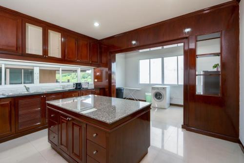 a large kitchen with wooden cabinets and a large island at Orchid Pool Villa Phuket - SHA Extra Plus in Phuket Town