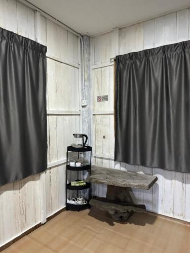 a room with a table and a curtain and a shelf at Haji Othman Farm in Kuala Terengganu