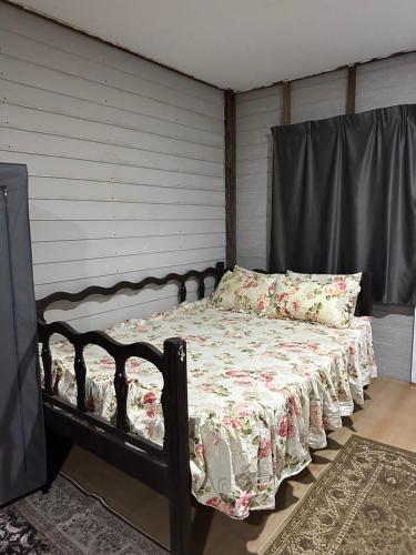 a bedroom with a bed with a floral comforter at Haji Othman Farm in Kuala Terengganu