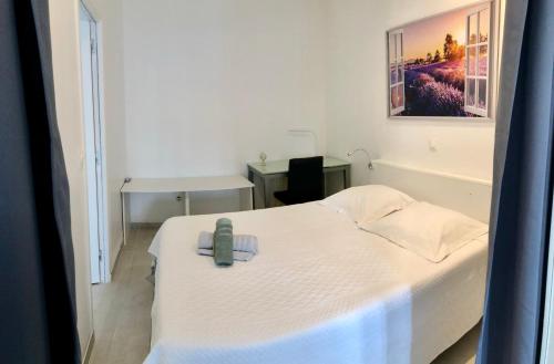 Un dormitorio con una cama blanca con un teléfono. en Cozy T2 Moulin de la Calade au Coeur du Var en Le Luc