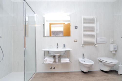 a bathroom with a sink and a toilet and a mirror at Hotel Cleofe in Caorle