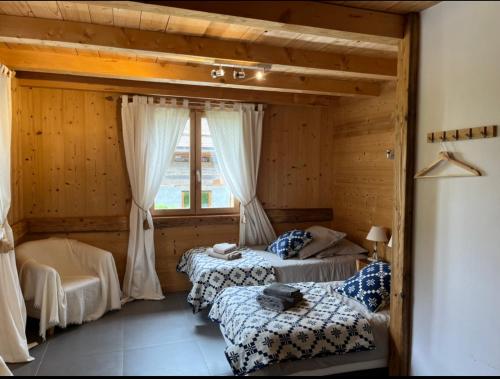 een slaapkamer met twee bedden en een raam bij Le Chalet du Crêt - 8 pers, tout confort avec Jacuzzi in Notre-Dame-de-Bellecombe