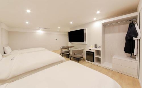 a hotel room with a bed and a desk and a tv at H Avenue Hotel in Gyeongju in Gyeongju