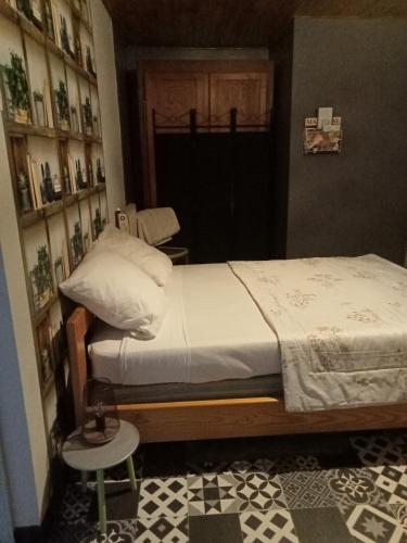 um pequeno quarto com uma cama e uma cadeira em Le repaire des écureuils em Bourg-Argental