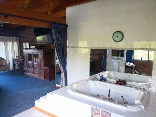 uma grande banheira branca num quarto em Tsitsikamma on Sea Resort em Witelsbos