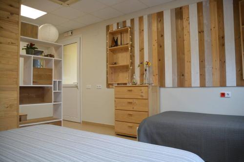um quarto com uma cama e uma cómoda e paredes de madeira em Apartament rural Can Ramon em Estanyol