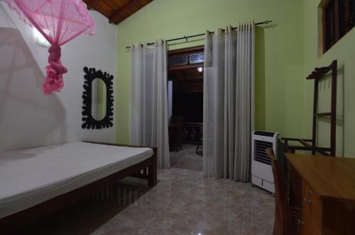 a bedroom with a bed and a mirror in a room at Binara Home Stay in Polonnaruwa