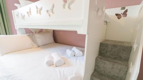 a bunk bed with two white slippers on it at Claremont in Llanfairfechan