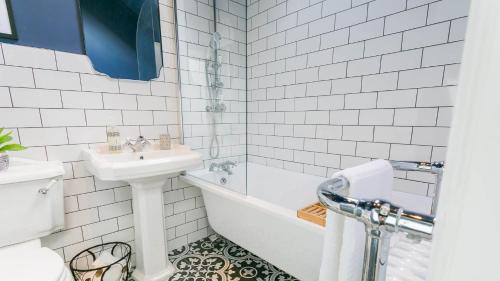 a bathroom with a sink and a tub and a toilet at Claremont in Llanfairfechan