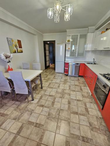a kitchen with a table and chairs and a dining room at Mitropolit Dosoftei Street Апартаменты in Chişinău