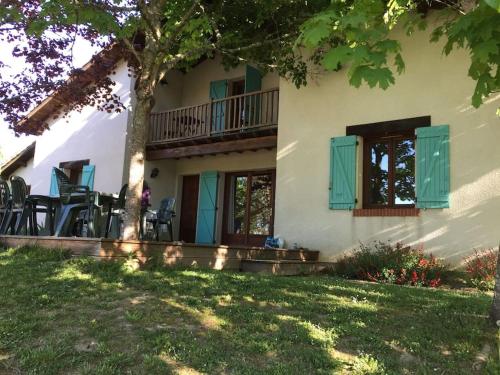 une maison avec des fenêtres vertes à volets et un arbre dans l'établissement Grande maison avec parc de 6000m2, à Pompiey