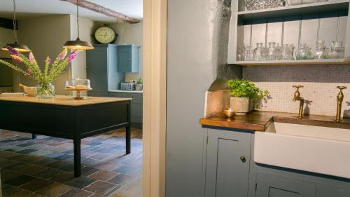a kitchen with a sink and a counter with a table at Ty Fry Manor in Pentraeth