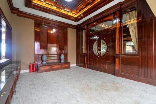 a large room with wooden walls and a clock on the wall at Orchid Pool Villa Phuket - SHA Extra Plus in Phuket Town