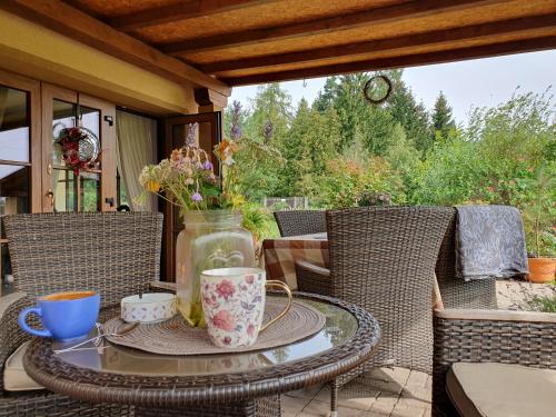 a table with a vase of flowers on a patio at Pokoj v zahradě in Hazlov