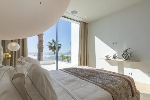 sypialnia z łóżkiem i widokiem na ocean w obiekcie Blue Sky Mallorca Luxury Villa w mieście Andratx