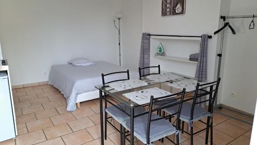 - une salle à manger avec une table, des chaises et un lit dans l'établissement Bellevue, à Saint-Paterne-Racan