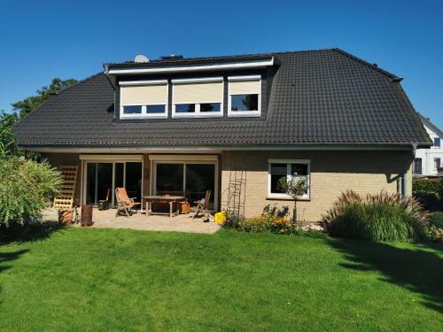 a house with a table and chairs in a yard at traumhaft edle Landhauswohnung in Rosengarten