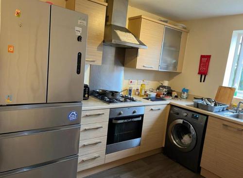 a kitchen with a stainless steel refrigerator and a dishwasher at No-323 Signals Drive in Coventry