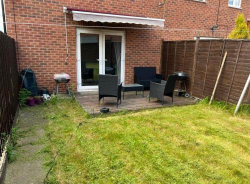a patio with chairs and a grill in a yard at No-323 Signals Drive in Coventry