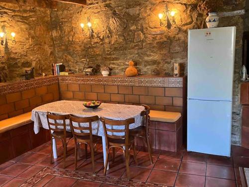 Il comprend une cuisine équipée d'une table, de chaises et d'un réfrigérateur. dans l'établissement Medulillas 1 Casa a 2000 m de Las Médulas, à Yeres