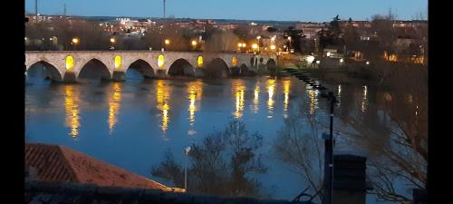 a bridge over a river with lights on the water at LOS PEPINOS ( mi lugar favorito ) in Zamora