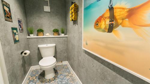 a bathroom with a fish on the wall next to a toilet at Mabuhay in Llanrhyddlad