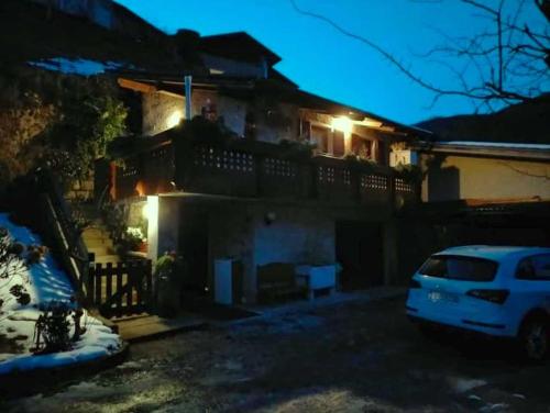 una casa con un coche aparcado en un estacionamiento por la noche en CASETTA INDIPENDENTE NEL VERDE PER 2/3 PERSONE, en Breguzzo