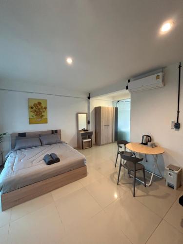 a bedroom with a bed and a table in it at Monkey Toe Guesthouse in Chiang Mai