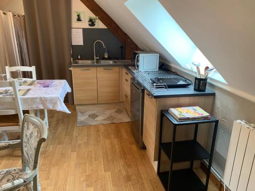 a kitchen with a sink and a counter with a stove at Gîte Bien-être in Yquebeuf
