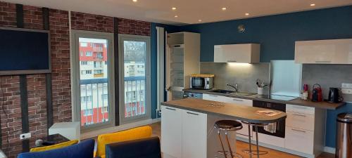 una cucina con pareti blu e tavolo e sedie di Appartement Rouen Ile Lacroix a Rouen