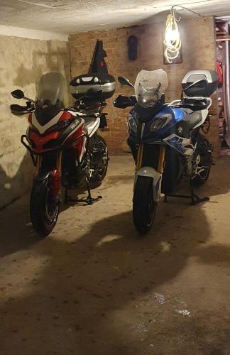 two motorcycles parked next to each other in a garage at Apartmani Podvisoki in Visoko