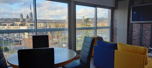 una stanza con tavolo e sedie e una grande finestra di Appartement Rouen Ile Lacroix a Rouen