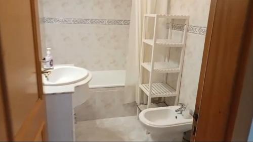 a white bathroom with a sink and a toilet at Rocha Gardens Apartment in Portimão