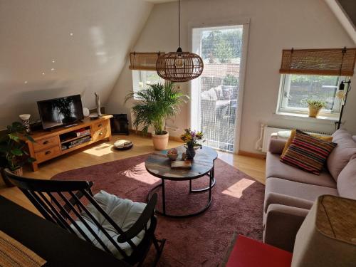 a living room with a couch and a table at Zonnig appartement Maasbommel. in Maasbommel