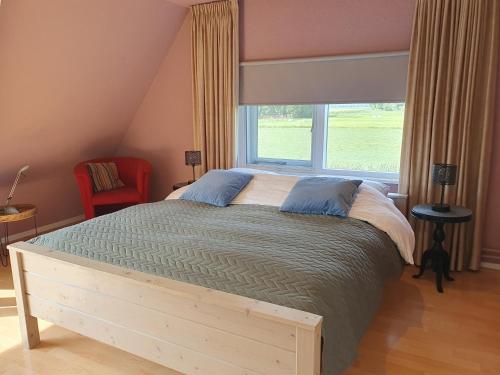 a bedroom with a large bed and a window at Zonnig appartement Maasbommel. in Maasbommel