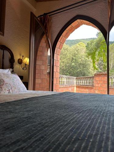 a bedroom with an archway with a bed and a window at Hotel Rural Convento Santa Maria de la Sierra in Arroyo Frio