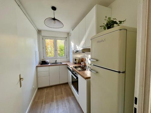 La cuisine est équipée d'un réfrigérateur et d'un évier. dans l'établissement Hana Home 4 personnes jardin privatif business&family, à Montigny-le-Bretonneux