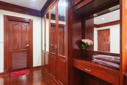 a bathroom with wooden cabinets and a vase of flowers at Orchid Pool Villa Phuket - SHA Extra Plus in Phuket Town