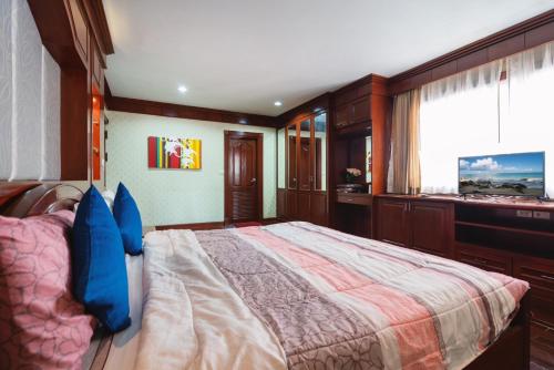 a bedroom with a large bed with blue pillows at Orchid Pool Villa Phuket - SHA Extra Plus in Phuket Town