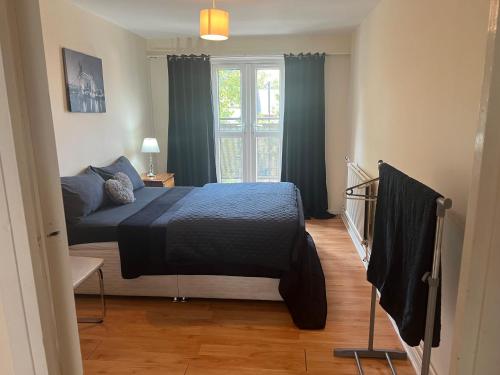 um quarto com uma cama e uma janela em Wilmot Close em Londres