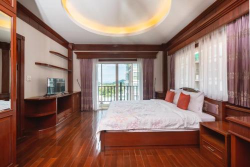 a bedroom with a bed and a large window at Orchid Pool Villa Phuket - SHA Extra Plus in Phuket Town