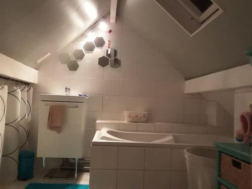 a white bathroom with a tub and a sink at Un nid près de Paris in Rueil-Malmaison