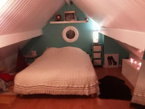 a bedroom with a white bed in a attic at Un nid près de Paris in Rueil-Malmaison