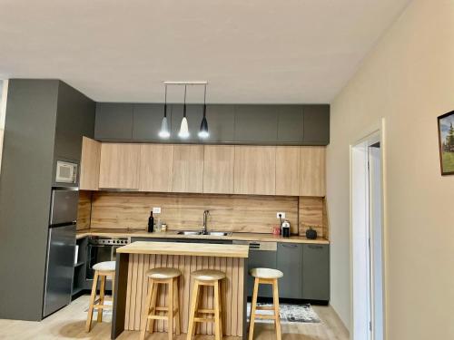 a kitchen with a counter and stools in it at Adra's apartment in Shkodër