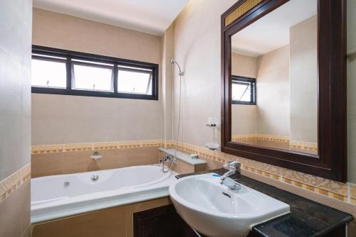 a bathroom with a sink and a tub and a mirror at Orchid Pool Villa Phuket - SHA Extra Plus in Phuket Town